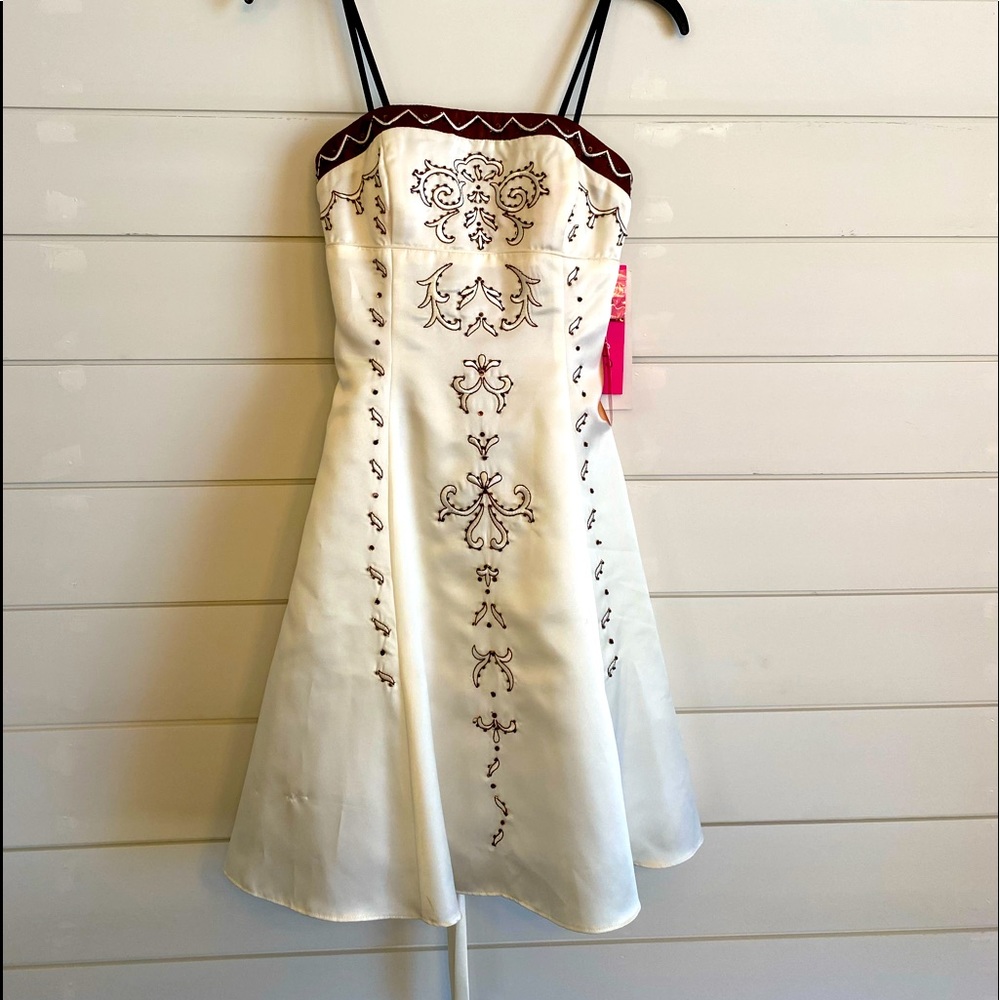 Ivory dress with brown accents/rhinestones. Back is a corset style tie. Size 3/4